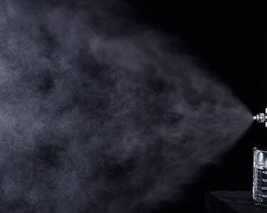 How does the atomizing nozzle atomize